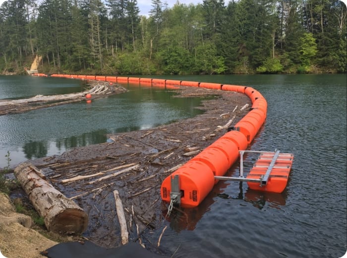 Floating boom barrier containing debris on water